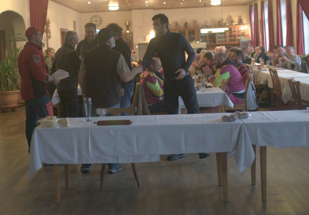 Bild zeigt die Preisübergabe bei der Siegerehrung im Saal des Gasthofs. Die Mannschaft ist nicht bekannt. Es sind jeweils die 4 Teilnehmer der jeweiligen Mannschaft zu sehen.