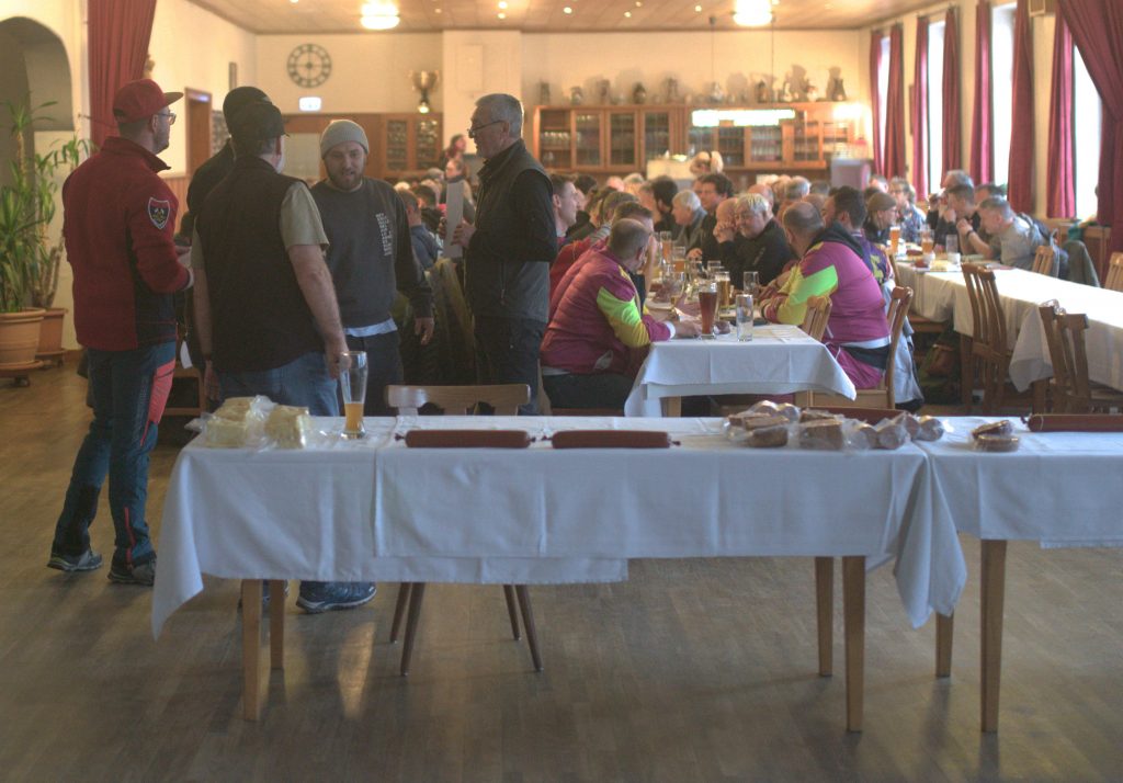 Bild zeigt die Preisübergabe bei der Siegerehrung im Saal des Gasthofs. Die Mannschaft ist nicht bekannt. Es sind jeweils die 4 Teilnehmer der jeweiligen Mannschaft zu sehen.