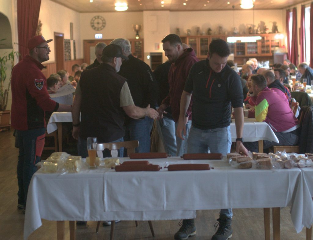 Bild zeigt die Preisübergabe bei der Siegerehrung im Saal des Gasthofs. Die Mannschaft ist nicht bekannt. Es sind jeweils die 4 Teilnehmer der jeweiligen Mannschaft zu sehen.