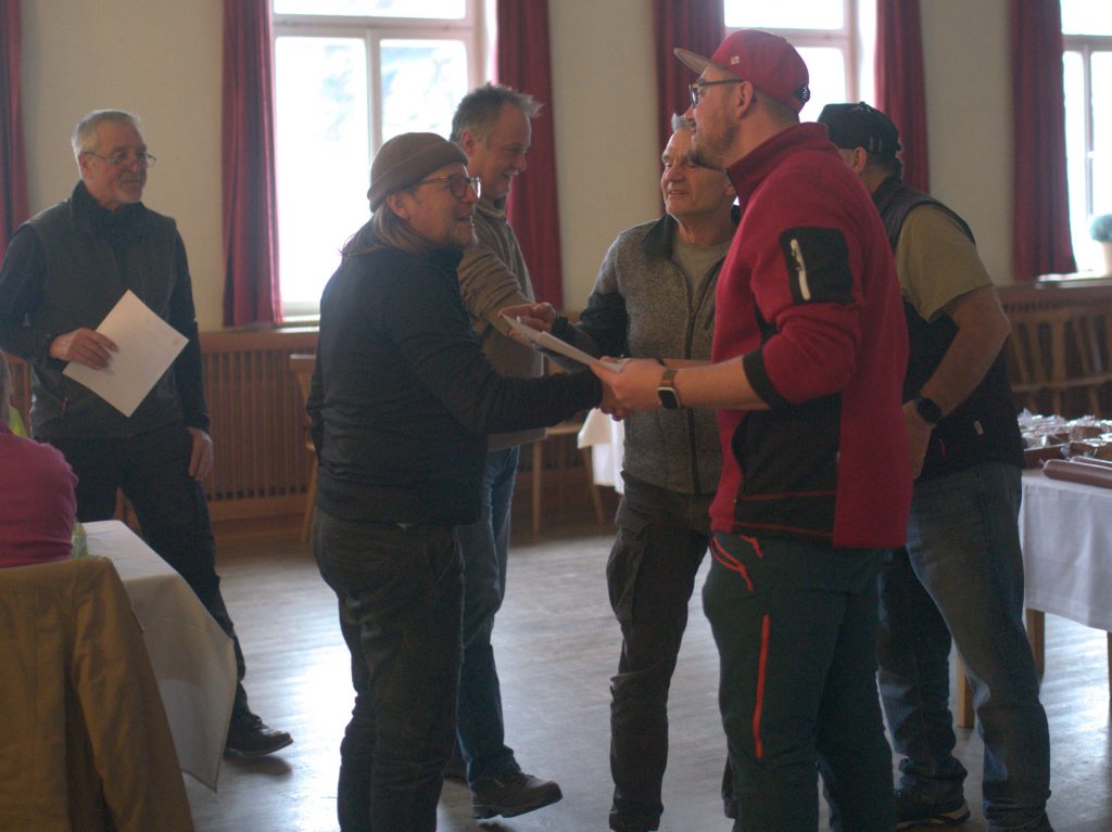 Bild zeigt die Preisübergabe bei der Siegerehrung im Saal des Gasthofs. Die Mannschaft ist nicht bekannt. Es sind jeweils die 4 Teilnehmer der jeweiligen Mannschaft zu sehen.