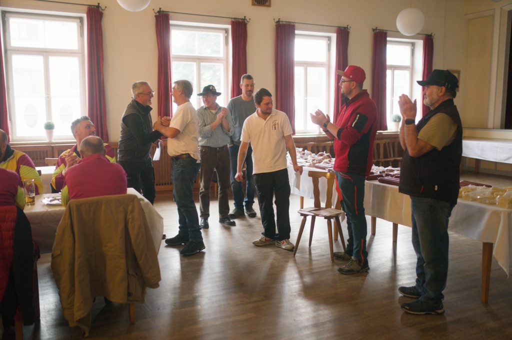 Bild zeigt die Preisübergabe bei der Siegerehrung im Saal des Gasthofs. Die Mannschaft ist nicht bekannt. Es sind jeweils die 4 Teilnehmer der jeweiligen Mannschaft zu sehen.