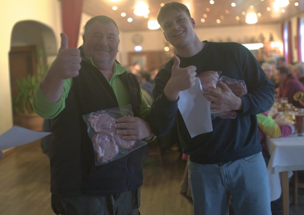 Bild zeigt zwei Teilnehmer mit Dauen Hoch und ein Lächeln im Gesicht. In der jeweiligen Hand die Sachpreise mit jeweils einem wakuumiert verpacktem Fleisch Stück.