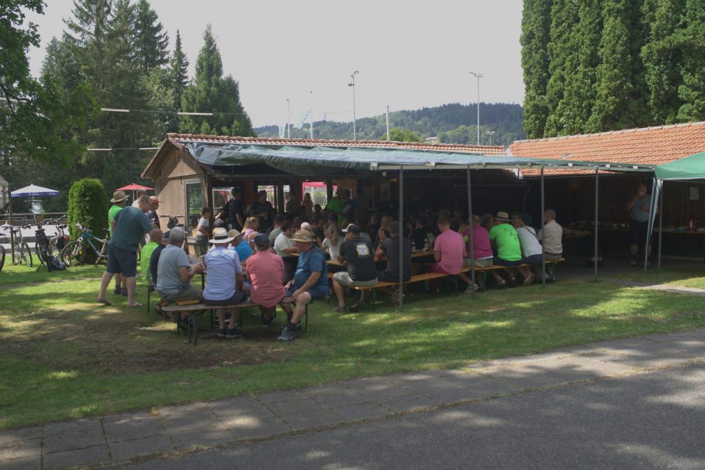 Foto zeigt die Stockschützenanlage mit einer Überdachung unter dieser sitzen die Gäste und Aktive.